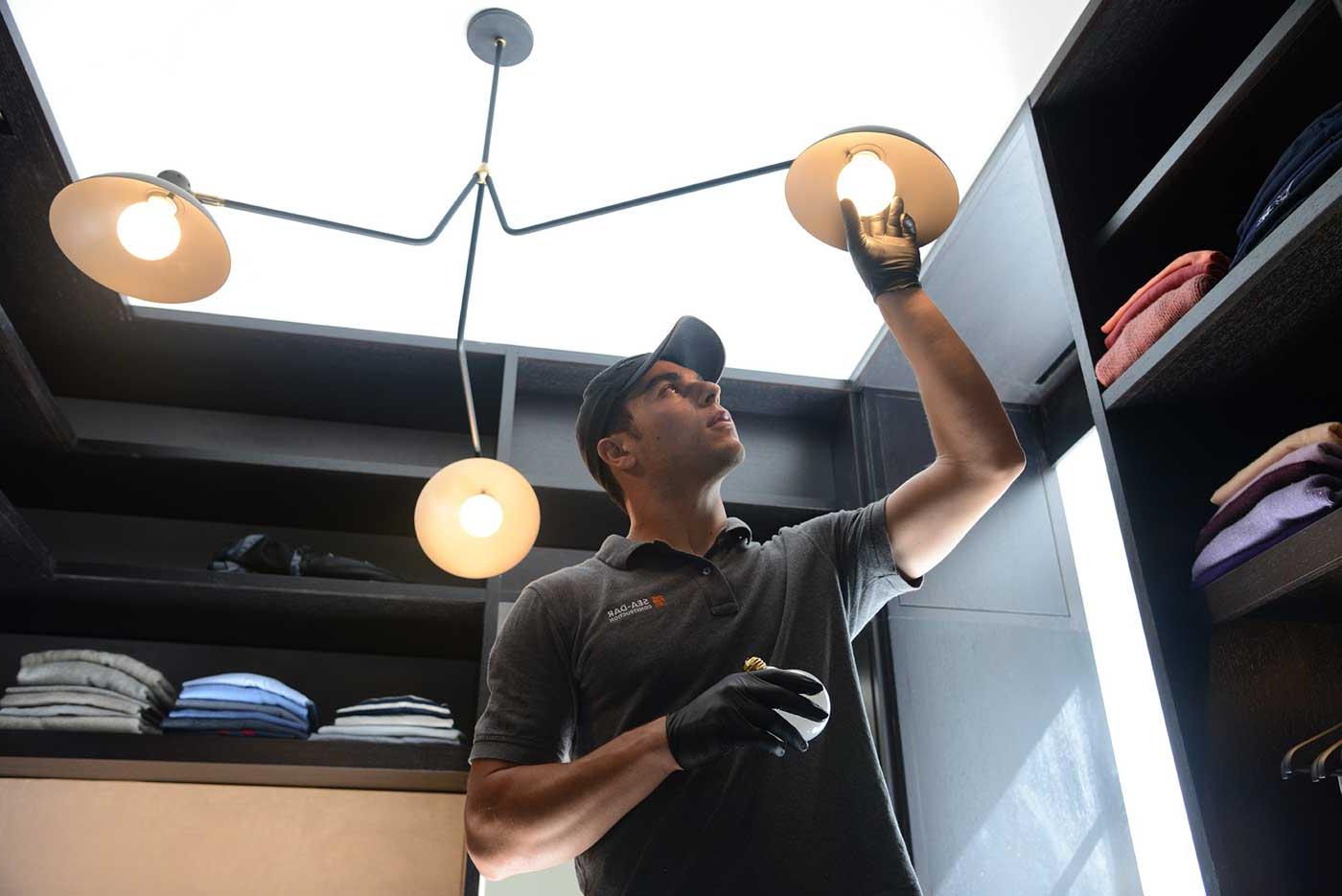 Man changing lightbulb in closet